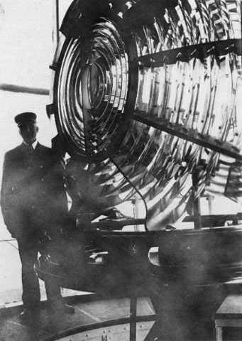 Black and white photograph of Franklin J. Covell by the Split Rock Lighthouse lens.