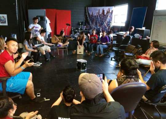 Color image of Hmong youth participate in Art Saves Us: Beyond the Noise, collaboratively creating original music in the Center for Hmong Arts & Culture’s (CHAT’s) St. Paul studio, May, 2013.