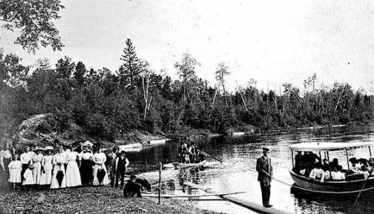 Photograph of a gathering of people on the banks of the upper Mississippi River for a prayer meeting conducted by Reverend John Sornberger c.1910.