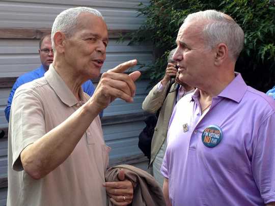 Color image of civil rights leader Julian Bond and Minnesota Governor Mark Dayton confering at a rally held to demonstrate opposition to Minnesota Marriage Amendment 1. Photographed by Bobak Ha’Eri on June 19, 2012.
