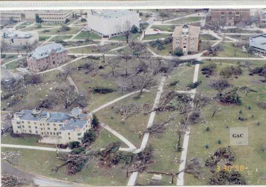 Color image of tornado damage in St. Peter, Minnesota, 1998. Image shows trees down and damage to a number of buildings. 