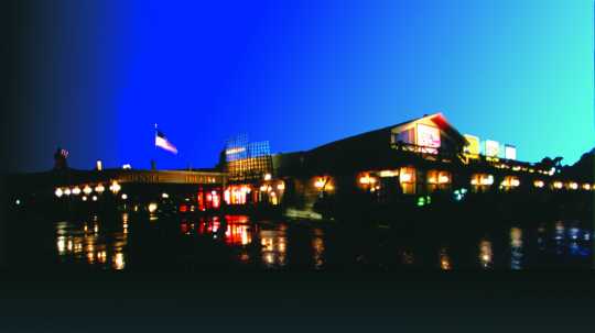 Color digital print of the exterior of Chanhassen Dinner Theatres at night.