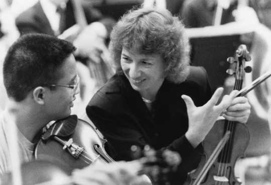Black and white photograph of SPCO musician Carolyn Daws working with local music students, 1983.