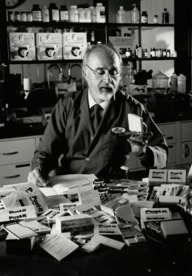 Black and white photograph of Arthur Fry inspecting his product, the Post-it Note, ca. 1980.