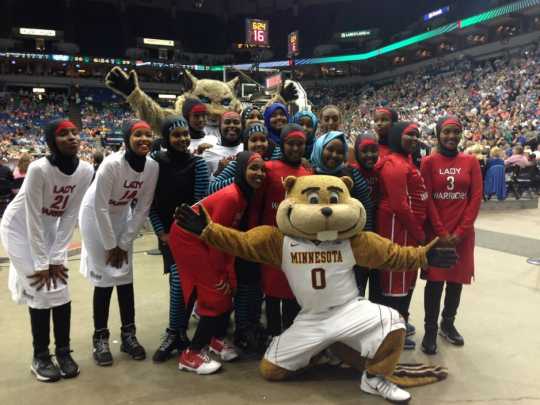 The Lady Warriors (a basketball team representing Cedar-Riverside, a neighborhood in Minneapolis) pose with the University of Minnesota mascot Goldy Gopher and Minnesota Lynx mascot Prowl during project recognition at a Minnesota Lynx WNBA game, August 30, 2015.