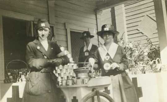 Black and white photograph of Evelyn Lightner (at left) and Red Cross workers distributing food, c.1918.