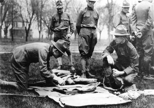 Black and white photograph of Candidates looking over United States Army kit at the Officers’ Training Camp, Fort Snelling, 1917. 