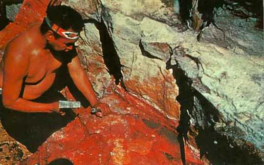 Color image of Standing Eagle working the sacred pipestone in a quarry at the Pipestone National Monument, ca. 1970.