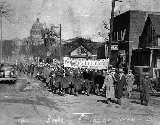 Photograph of marchers on a St. Paul street under a Farmers' Holiday sign