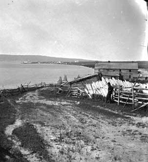 Black and white photograph of a view of La Pointe with Bayfield in the distance, 1875.