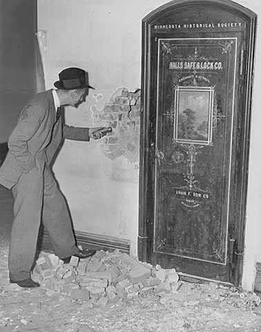 Black and white photograph of Richard Sackett examining the Minnesota Historical Society vault door in the second capitol building prior to its demolition, 1937.