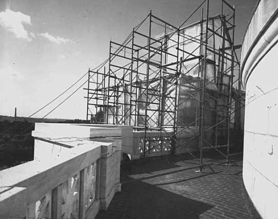 Black and white photograph of the Quadriga encased in scaffolding during application of gold leaf, 1979. Photographed by Elizabeth M. Hall.