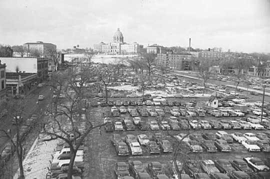 Black and white photograph of the Capitol approach, with Wabasha Street on the left, Cedar Street on the right, showing the site of the second state capitol as a parking lot, 1954.