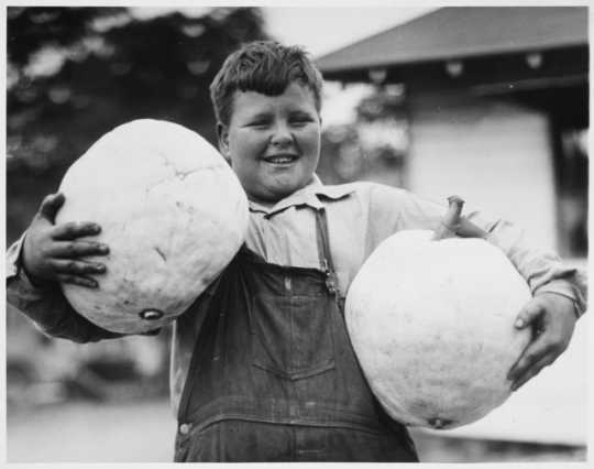 Black and white photograph of boy holding squash entered in the 1934 State Fair.