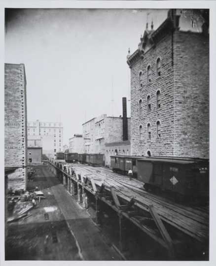 Black and white photograph of riverfront flour mills before the 1878 explosion.