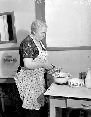 Black and white photograph of a woman using an electric mixer, 1938. Photographed by the Minneapolis Star Journal.