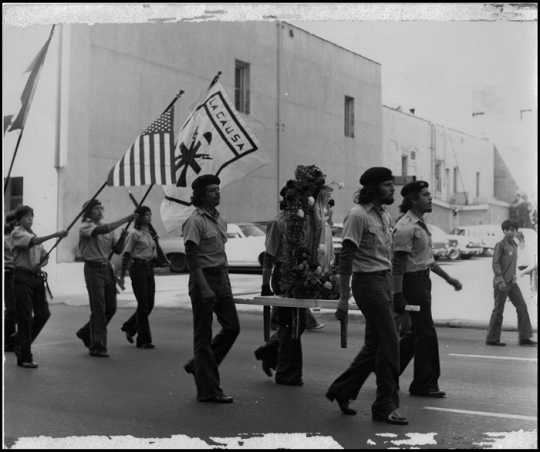 Brown Berets marching with flags