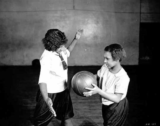 Black and white photograph of two girls playing basketball at Phyllis Wheatley House, ca. 1925.