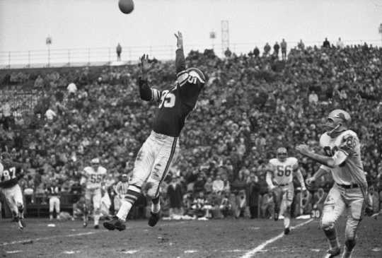 Black and white photograph of Paul Flatley catching a pass, Minnesota Vikings and Detroit Lions football game at Metropolitan Stadium Bloomington, 1963.