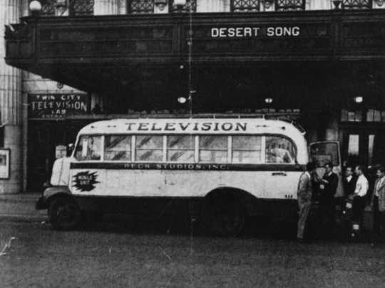 Black and white photograph of a Twin City Television Lab mobile unit in front of the Lyceum Theater and the Lab’s main entrance, c.1948.
