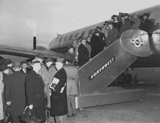 Black and white photograph of passengers boarding a Northwest Airlines plane, c.1946. Photographed by Philip C. Dittes.