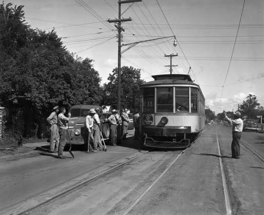 Black and white photograph of the last streetcar to run on France between Forty-Forth Street and Fifty-Forth Street passes the work crew that is about to tear up the track, August 10, 1952.