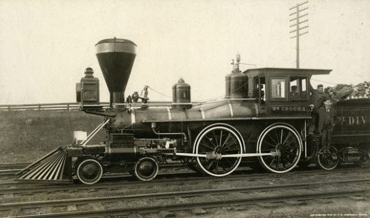 Black and white photograph of James J. Hill with two engineers on the William Crooks train engine, 1908. Photograph by T.W. Ingersoll. 