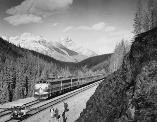 Black and white photograph of the Great Northern streamliner train in Glacier National Park, ca. 1955. Photograph by the Great Northern Railway.