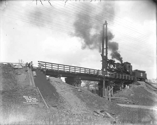 Black and white photograph of a construction crew at work on a bridge along the right of way, 1929. Photograph by Briol Studio.