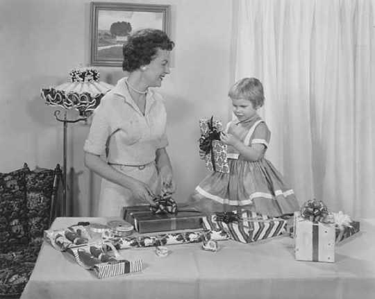 A mother and her daughter wrap gifts with Sasheen ribbon in this ca. 1955 advertisement for 3M.