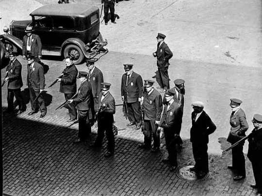 Black and white photograph of police with guns on a Minneapolis street during the strike, 1934.