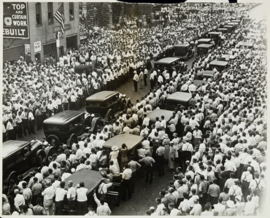 Black and white photograph of the funeral of Henry Ness, a striker killed during the strike, in front of strike headquarters at 215 South Eighth Street, Minneapolis, 1934. 