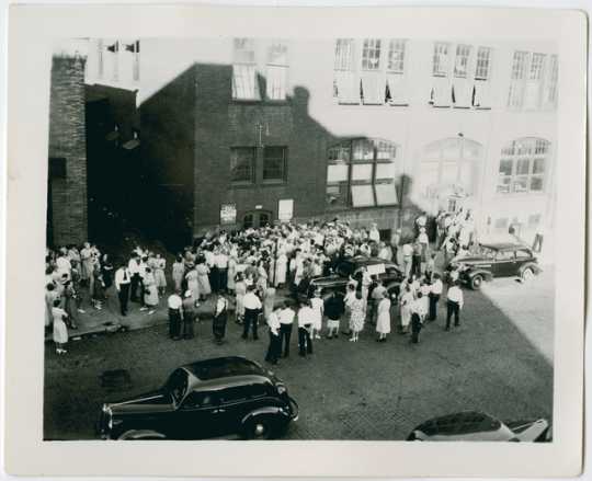 Crowd demonstrating in front of the Minneapolis sewing project