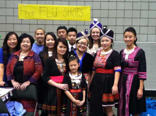 Color image of participants in the Operation Free Flu Shot program gather for a group photograph at Hmong Village in St. Paul on October 27, 2013. 