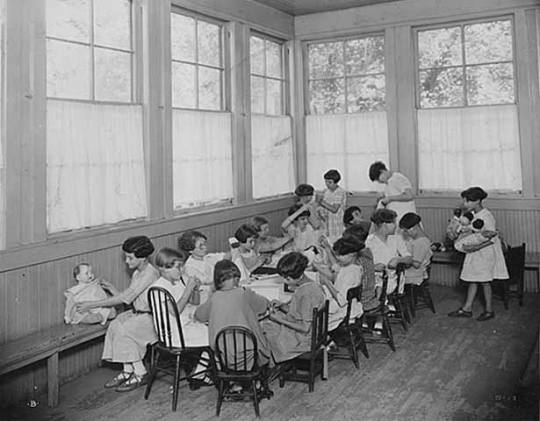 Black and white photograph of girls with dolls at the Emanuel Cohen Center in Minneapolis c.1925.