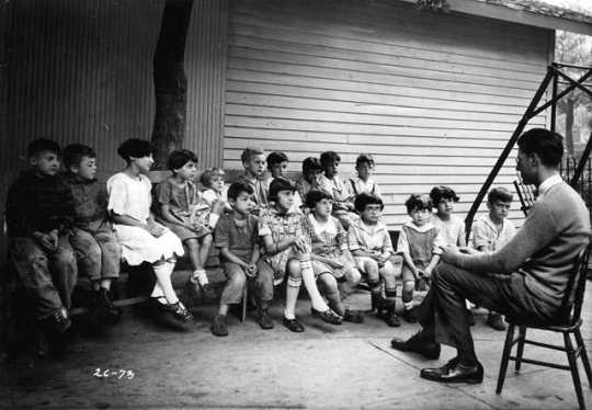 Black and white photograph of a man telling a story to residents of the Jewish Sheltering Home for Children in Minneapolis, c.1925.