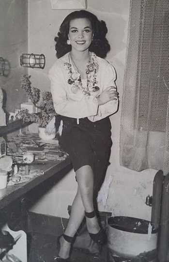 Black and white photograph of Hilda Simms posed for a photo in her dressing room, c.1943.