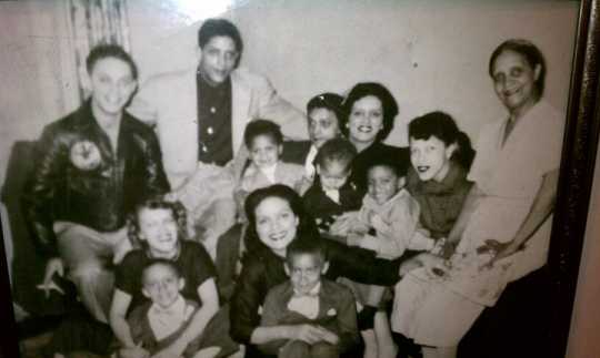 Black and white photograph of Hilda Simms surrounded by her mother, several of her siblings, and nephews, c.1955.