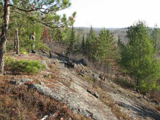 Color image of a hiker on rocky hill in Lake Vermilion–Soudan Underground Mine State Park. Photograph by Minnesota Department of Natural Resources Staff, October 30, 2007.