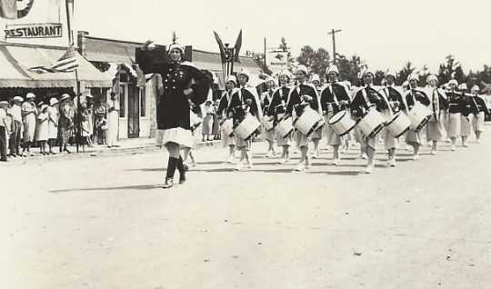 Black and white photograph of the American Legion Auxiliary drum and bugle corps on parade in Bagley, Minnesota, 1935.