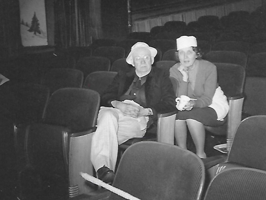 Black and white photograph of Charles and Louise Hiller sitting in theater seats, ca. 1940s.