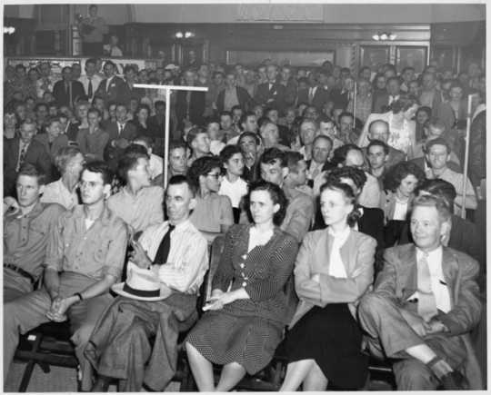 Black and white photograph of a Socialist Workers Party meeting, ca. 1940. Vincent R. Dunne and Grace Carlson sit in the center of the front row.