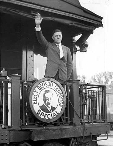 Black and white photograph of Elmer Benson waving from a campaign train, c.1936.   