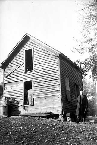 Frank B. Kellogg posed by the ruins of his old home in Olmsted County