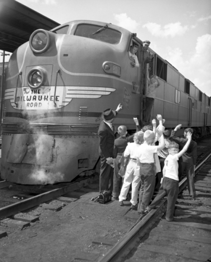 Black and white photograph of agroup of kids visiting a Milwaukee Road locomotive. Photograph by the Star Tribune Company, April 4, 1948.