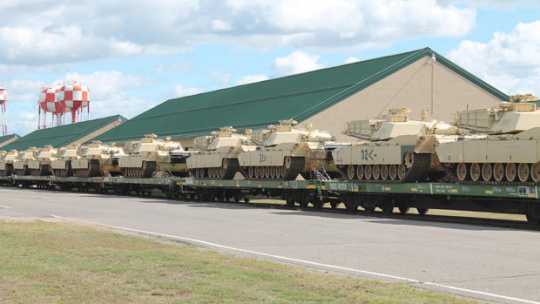 Color image of M1 Abrams tanks arrive at Camp Ripley on flatcars, 2015.  
