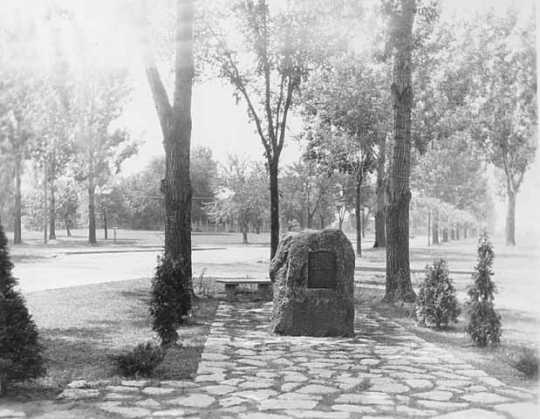 Black and white photograph of a monument erected to the memory of Colonel Josiah Snelling in front of the Fort Snelling Memorial Chapel, 1929.