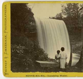 Black and white photograph of visitors below the falls, c.1869.