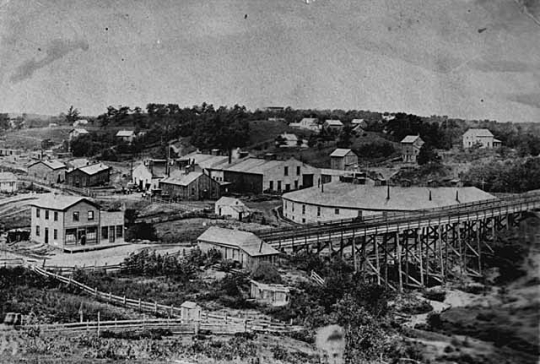 Black and white photograph of shops and roundhouse of the First Division, St. Paul and Pacific Railroad, a predecessor of Great Northern, St. Paul, 1875.