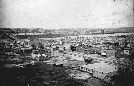 Black and white photograph of the lower West Side and Wabasha Bridge, c.1885. 